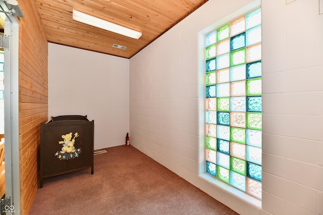 carpeted spare room with visible vents and wooden ceiling