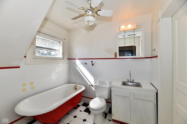 full bathroom with ceiling fan, toilet, a freestanding tub, tile patterned floors, and vanity