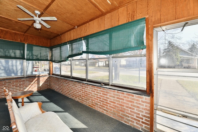 unfurnished sunroom with wood ceiling and ceiling fan