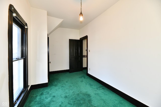 carpeted spare room with plenty of natural light and baseboards