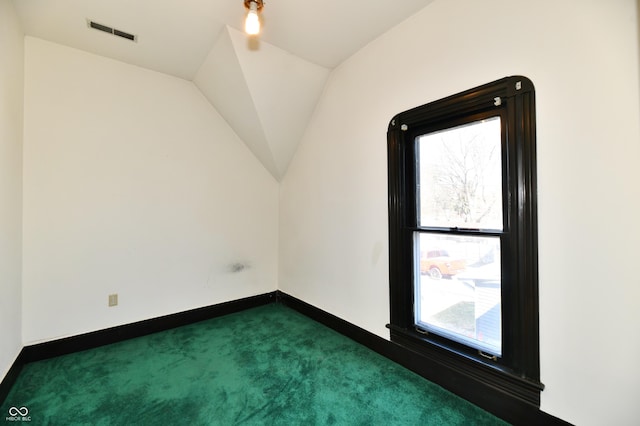 bonus room featuring vaulted ceiling, baseboards, visible vents, and dark colored carpet