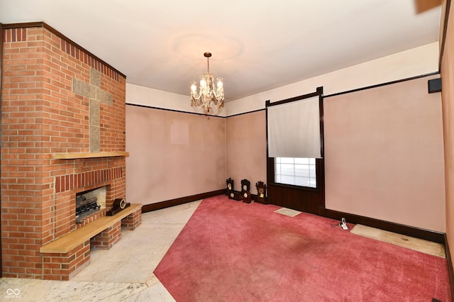 interior space with a barn door, a notable chandelier, a fireplace, and baseboards