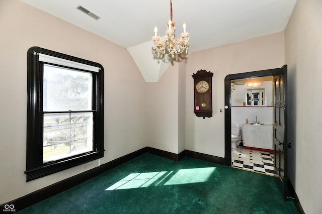 carpeted empty room with visible vents, an inviting chandelier, baseboards, and a sink