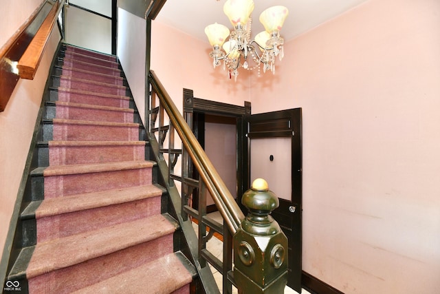 stairs featuring a notable chandelier