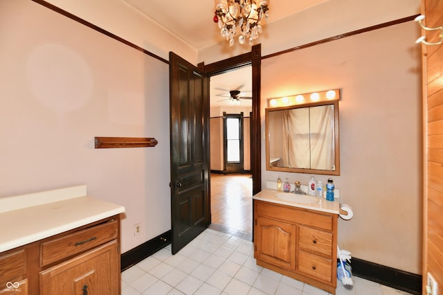 bathroom with tile patterned floors, baseboards, a chandelier, and vanity