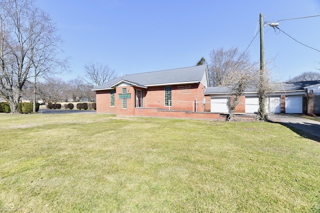 exterior space with an attached garage, a yard, brick siding, and driveway