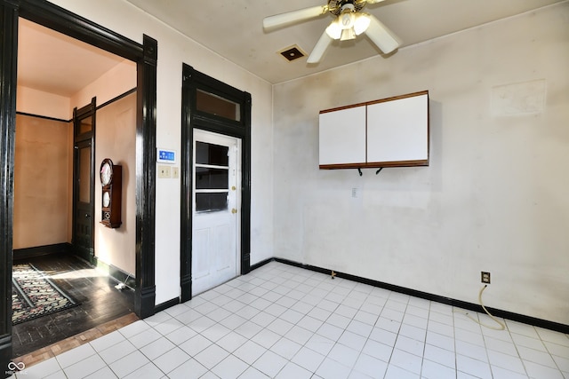 unfurnished room featuring a barn door, baseboards, and a ceiling fan