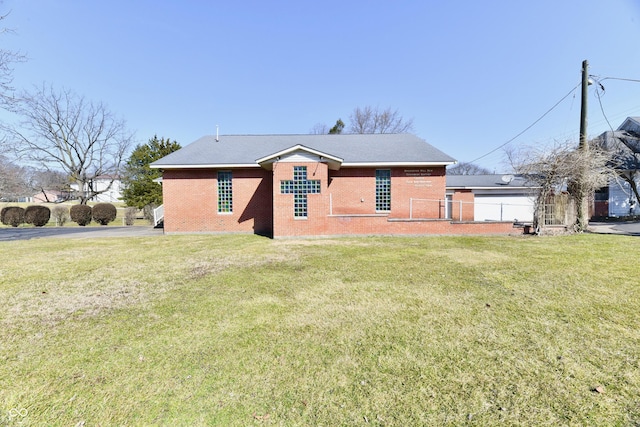 back of property featuring a yard, fence, and brick siding