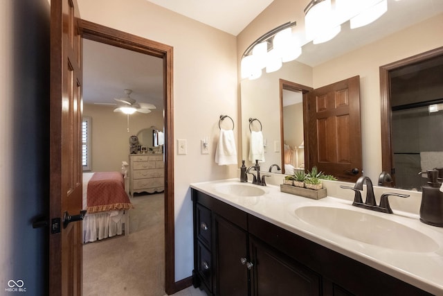 ensuite bathroom with a sink, connected bathroom, a ceiling fan, and double vanity