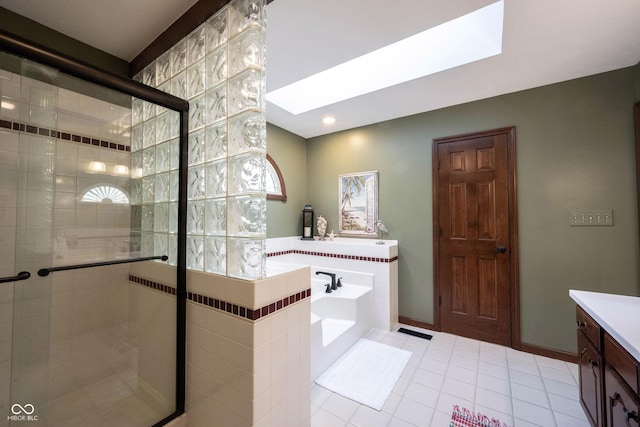 bathroom featuring baseboards, a skylight, a stall shower, tile patterned flooring, and a garden tub