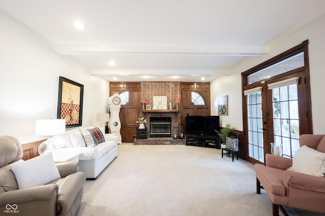 living area featuring beam ceiling, a fireplace, recessed lighting, french doors, and light carpet