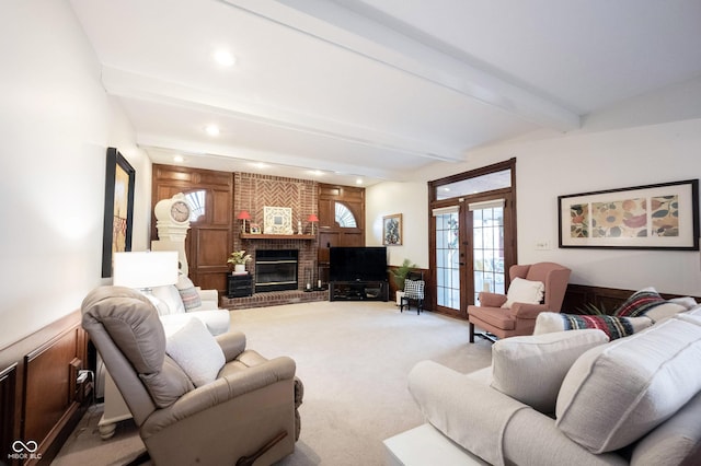 living room featuring carpet, beam ceiling, recessed lighting, french doors, and a brick fireplace