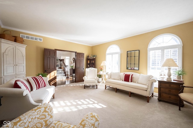 carpeted living room featuring stairway, visible vents, and ornamental molding