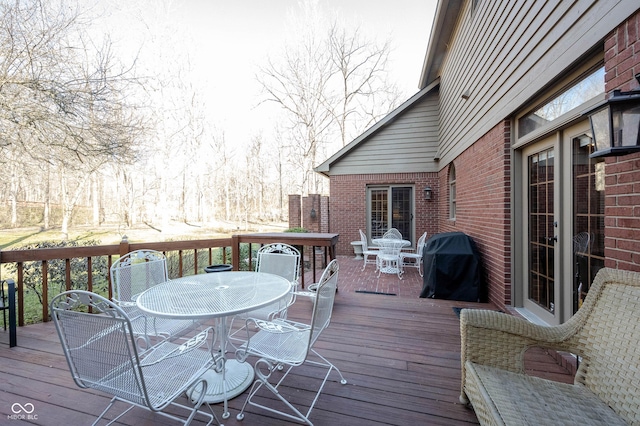 wooden deck featuring outdoor dining area and a grill