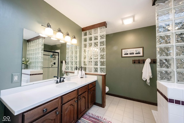 bathroom with vanity, baseboards, a stall shower, tile patterned floors, and toilet