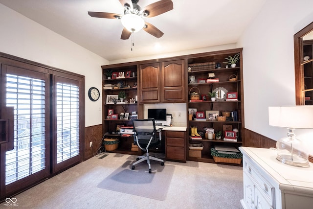 home office with a wainscoted wall, light colored carpet, and wooden walls