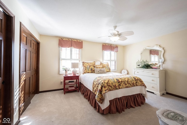 bedroom featuring light carpet, a ceiling fan, and baseboards