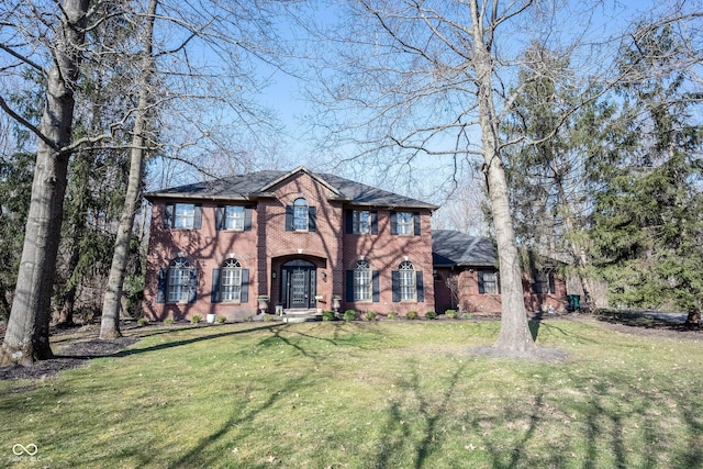 colonial house with a front lawn and brick siding