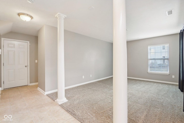 below grade area featuring light tile patterned floors, visible vents, baseboards, and light colored carpet