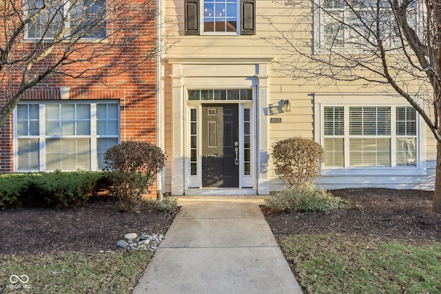 view of exterior entry featuring brick siding