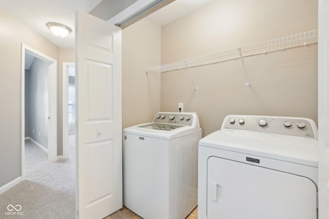 laundry area with laundry area, light colored carpet, baseboards, and washer and clothes dryer