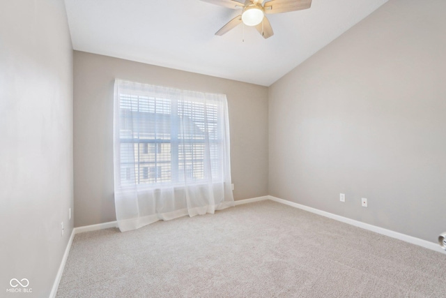 carpeted empty room featuring vaulted ceiling, baseboards, and ceiling fan