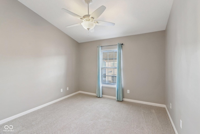 empty room with vaulted ceiling, light carpet, baseboards, and ceiling fan