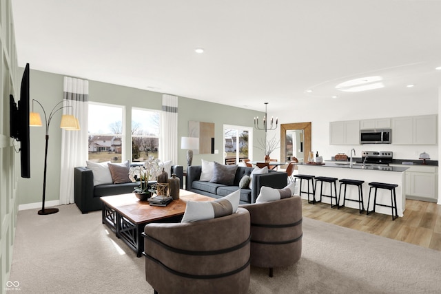 living area with a notable chandelier, recessed lighting, and light carpet