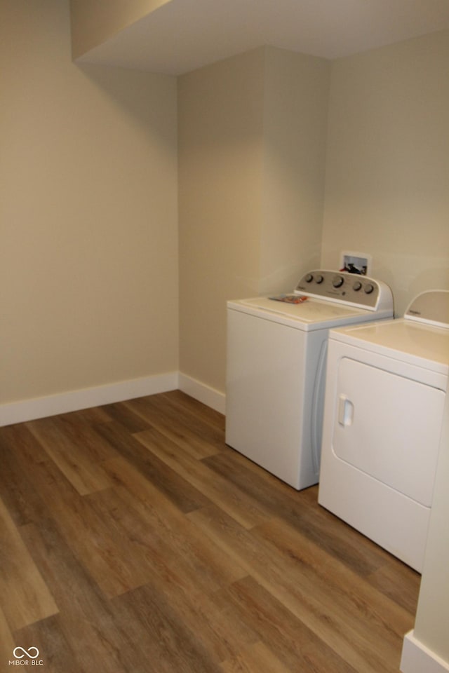 laundry area with laundry area, light wood-type flooring, baseboards, and separate washer and dryer