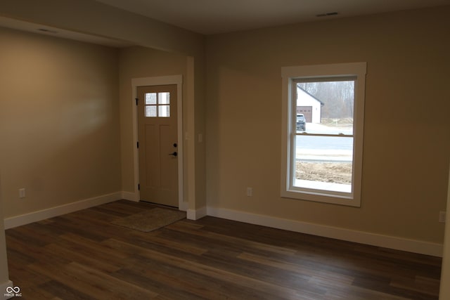 foyer with visible vents, baseboards, and dark wood-style flooring