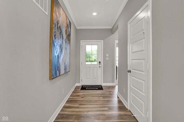 doorway featuring visible vents, ornamental molding, wood finished floors, recessed lighting, and baseboards