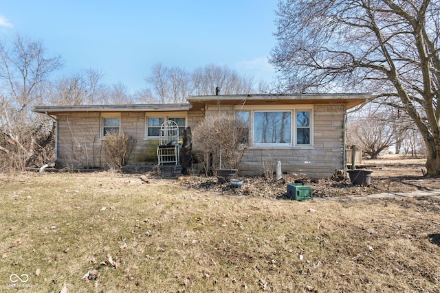 view of front facade with a front lawn and stone siding