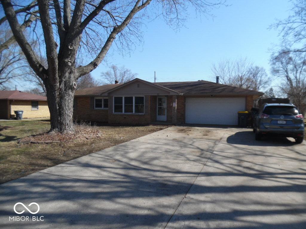 ranch-style house featuring a garage, brick siding, and concrete driveway