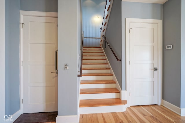 stairs featuring wood finished floors and baseboards