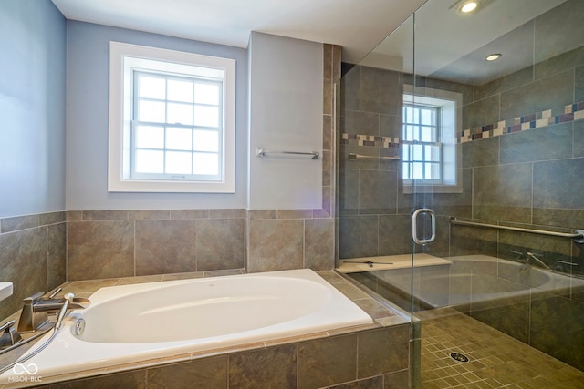 bathroom with plenty of natural light, a bath, and a shower stall