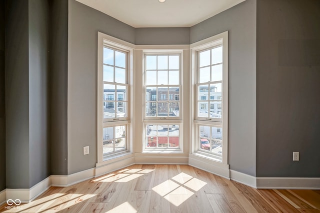 empty room with baseboards and wood finished floors