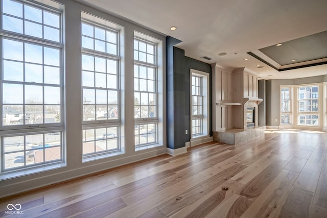 unfurnished living room featuring recessed lighting, a fireplace, baseboards, and light wood finished floors