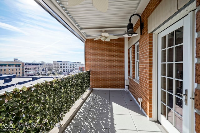 balcony with a city view, ceiling fan, and a sunroom