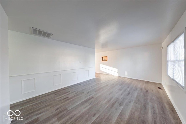 unfurnished room featuring visible vents and wood finished floors