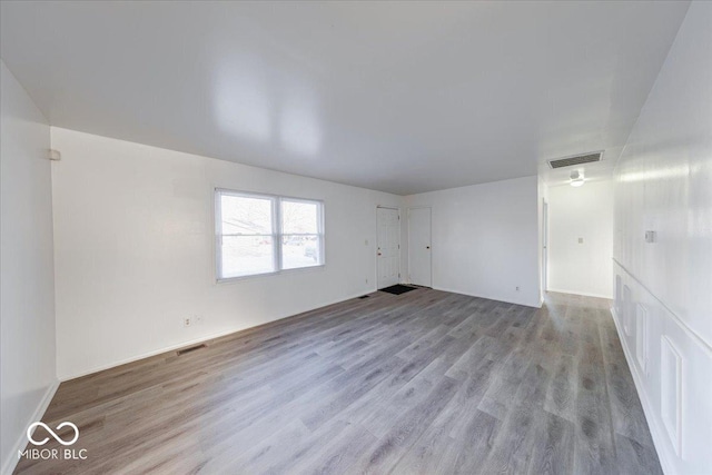 empty room featuring visible vents and wood finished floors