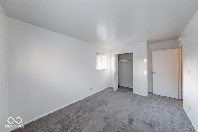 unfurnished bedroom featuring a closet, baseboards, and carpet