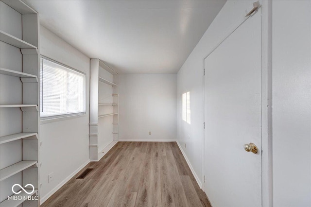 unfurnished room featuring wood finished floors, baseboards, and visible vents