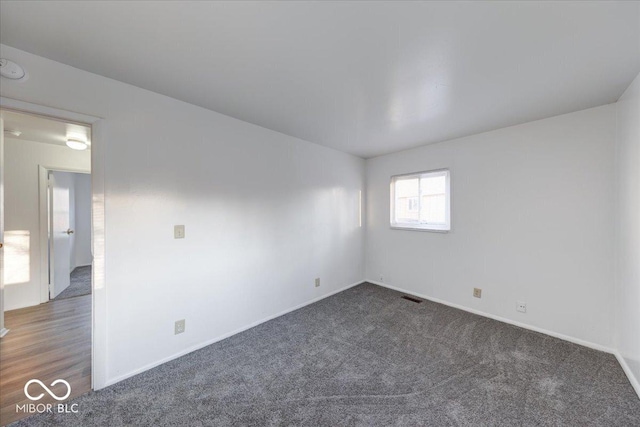 spare room featuring visible vents, baseboards, and carpet