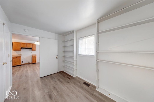 interior space featuring visible vents, light wood-type flooring, and baseboards