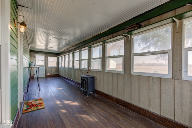 unfurnished sunroom featuring a wood stove