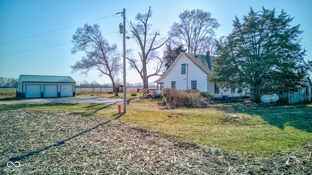 view of yard featuring a garage and an outbuilding