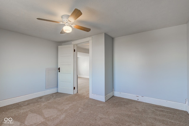 unfurnished room featuring carpet flooring, a textured ceiling, baseboards, and a ceiling fan