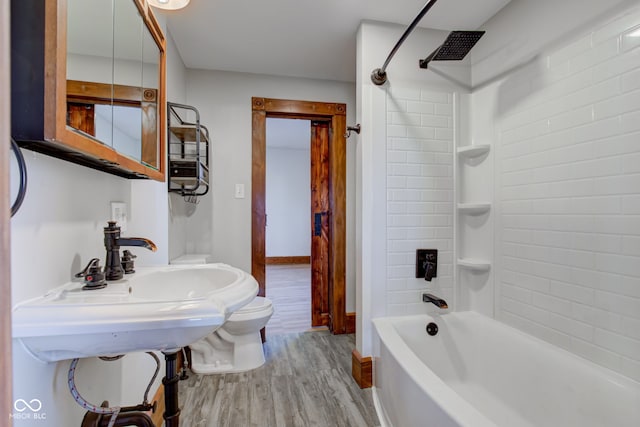 full bathroom featuring toilet, wood finished floors, baseboards, and shower / bath combination