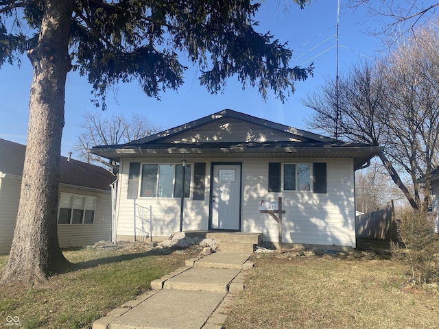 bungalow with a front yard and fence