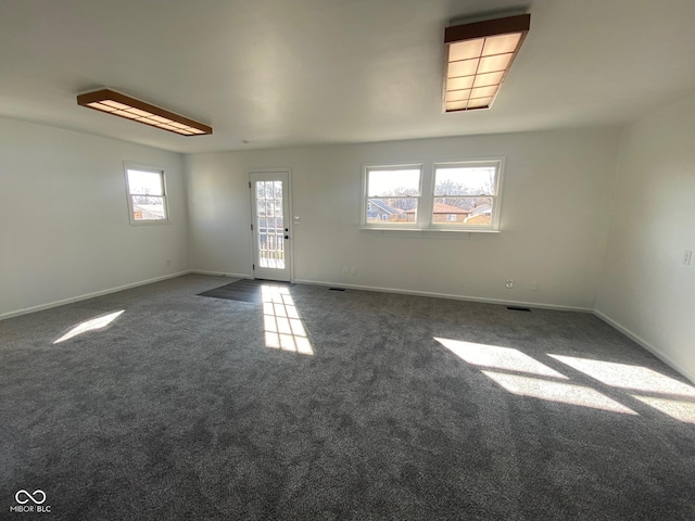 carpeted spare room featuring visible vents and baseboards